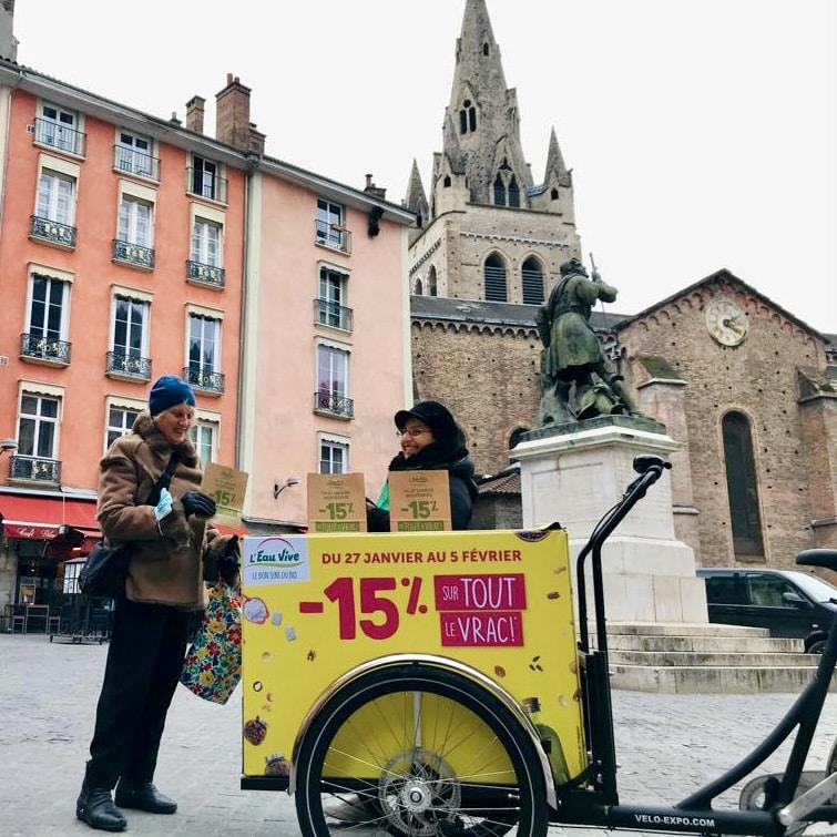 Velo Expo pour les magasins l'Eau Vive à Grenoble France. Animation, distribution et échantillonnage avec vélo affichage mobile grand format. Campagne communication ooh hors-media par activation affichage mobile digital avec vélo triporteur publicitaire street marketing | Velo Expo | Agence Veymont