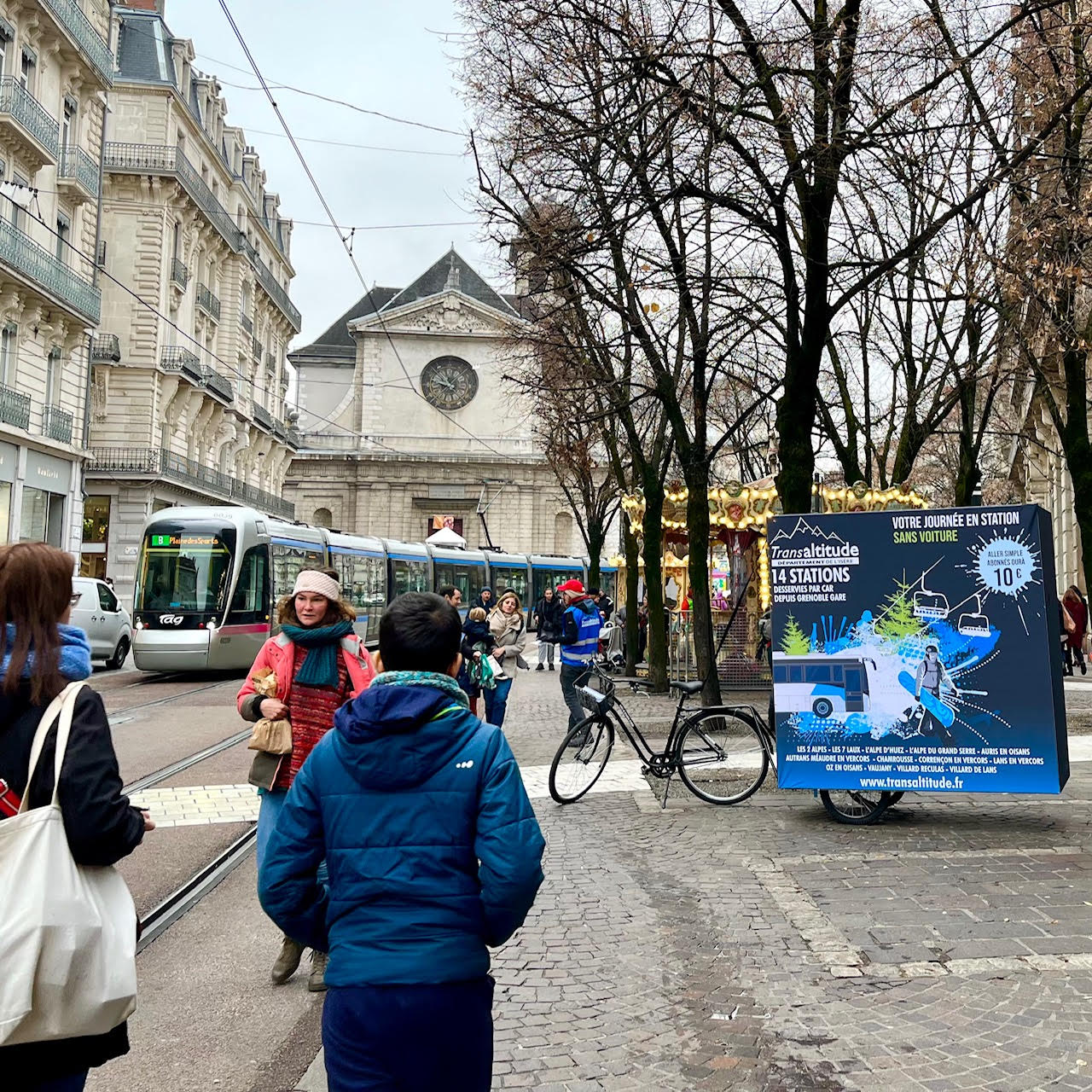 Place place Victor Hugo Grenoble. Velo Expo VFD TransAltitude à Grenoble France. Affichage mobile, animation drive-to-web, distribution de flyers avec vélo triporteur et remorque affichage mobile cube grand format. Campagne communication ooh hors-media par activation affichage mobile digital avec vélo triporteur publicitaire street marketing | Velo Expo | Agence Veymont