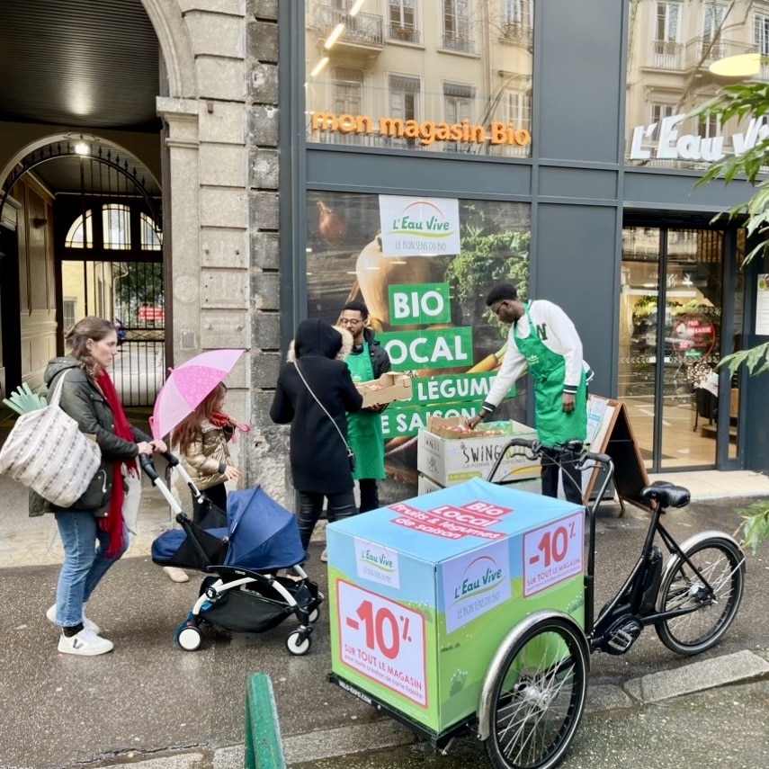 Velo Expo pour les magasins l'Eau Vive à Lyon. Animation, distribution et échantillonnage avec vélo affichage mobile grand format. Campagne communication ooh hors-media par activation affichage mobile digital avec vélo triporteur publicitaire street marketing | Velo Expo | Agence Veymont